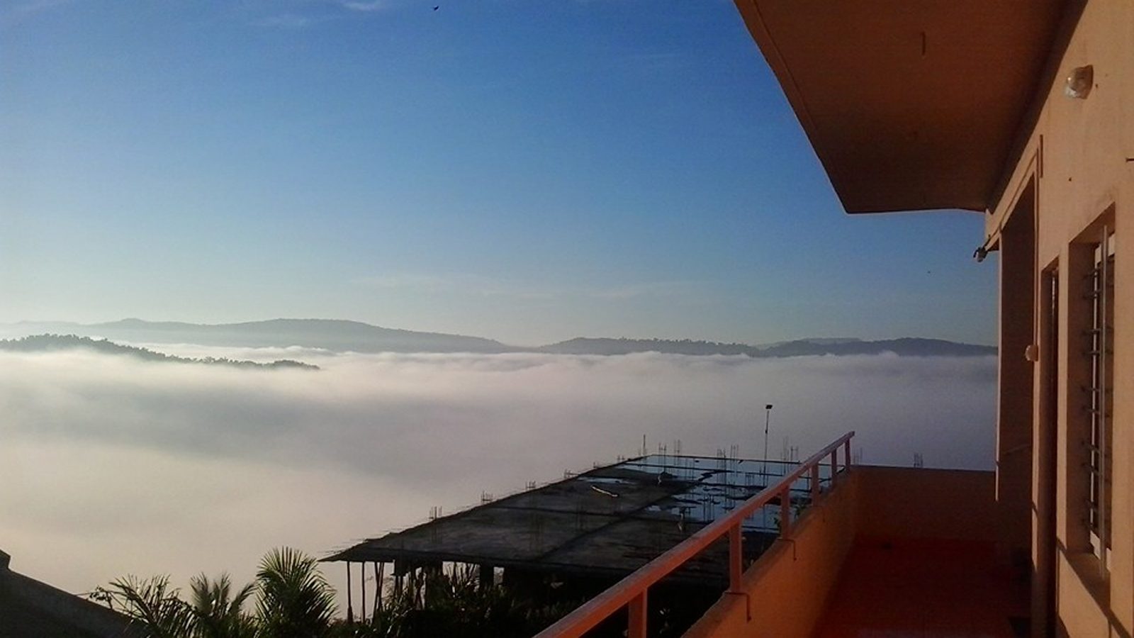 View of clouds over the valley from a balcony at the Anandkunj campus