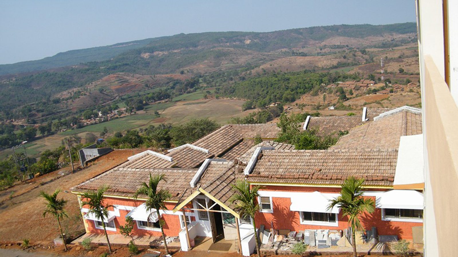 Anandkunj campus buildings on a green hillside, seen from above