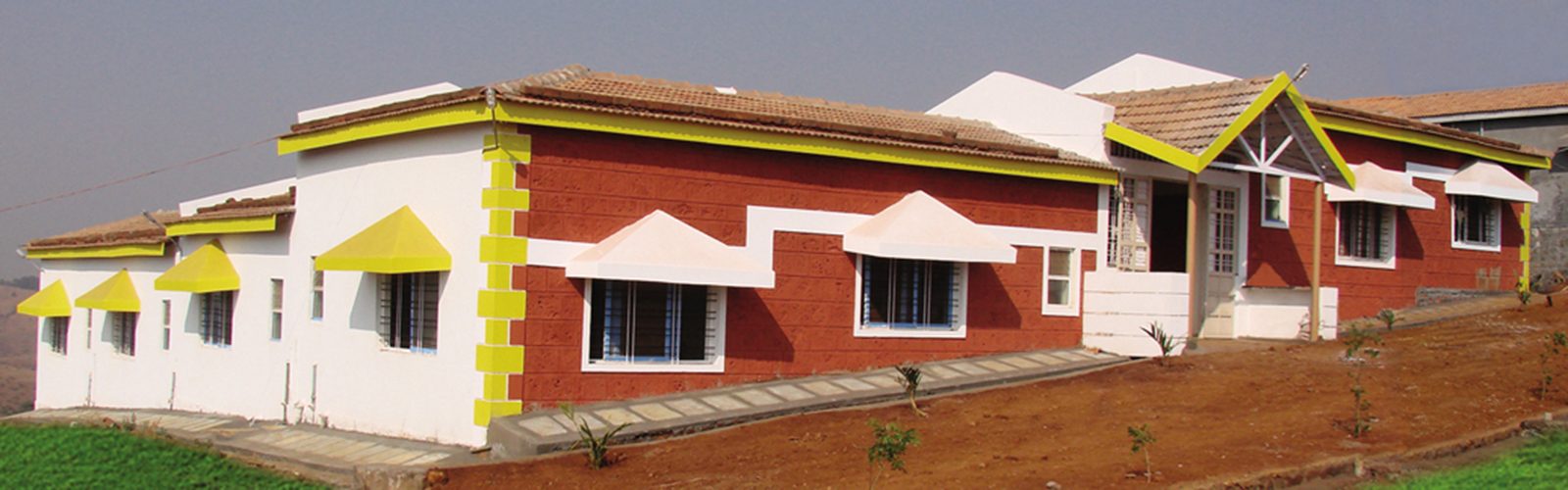 Red and white cottage building at the Anandkunj campus