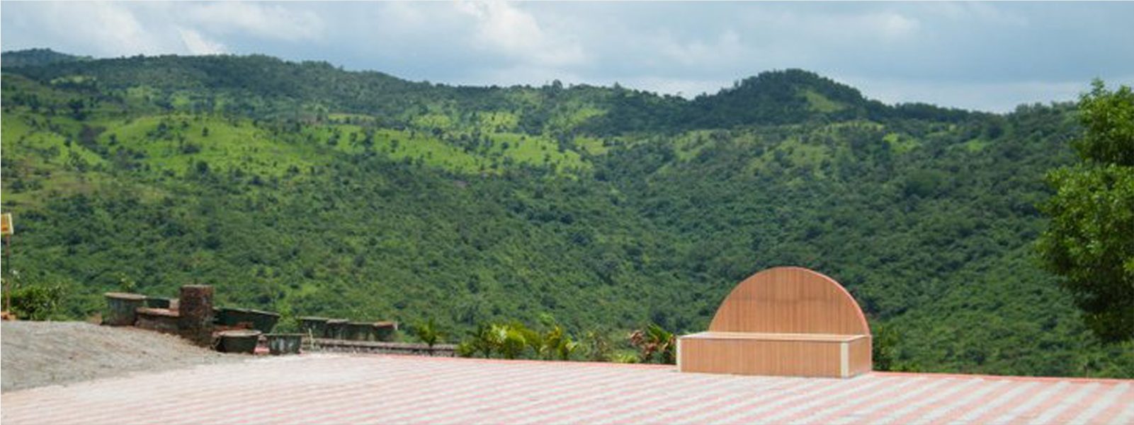 Hilltop terrace at Anandkunj with green hills in the distance